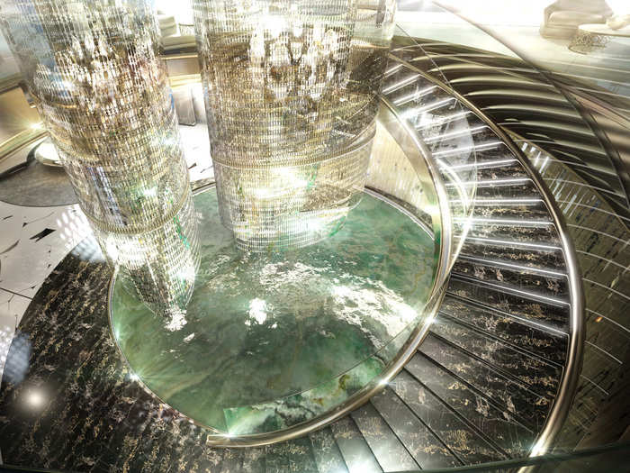 The centerpiece of the salon is a huge chandelier surrounded by a circular staircase.