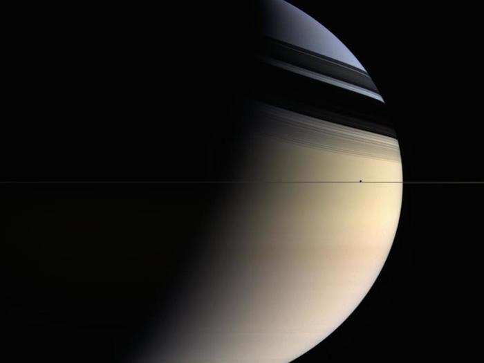 Below is a distant look at Enceladus, which is the tiny speck right of center just above the thin line marking Saturn