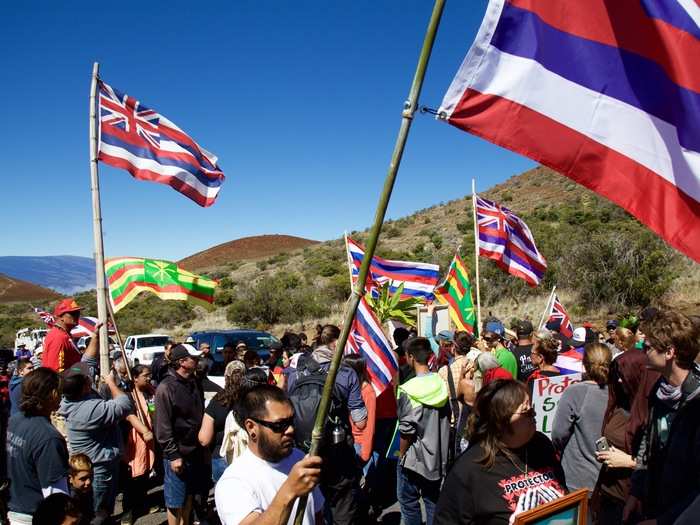 Police and officials from the Defense of Land and Natural Resources (DLNR) quickly arrived on the scene. For the first hour or so, no one moved up the mountain. The protesters marched back and forth along one of the crossing signs by the Visitor