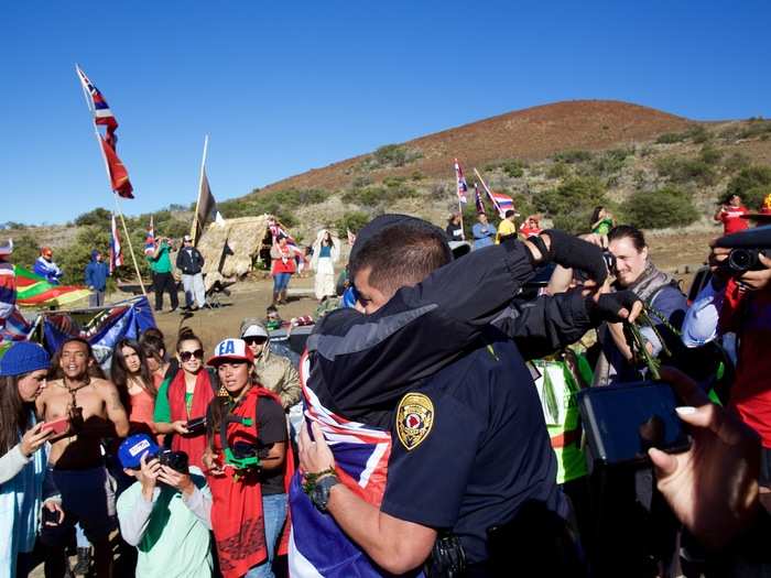 A stillness swept over the crowd as this happened. One protester embraced the leied police officer. The kids followed her example.