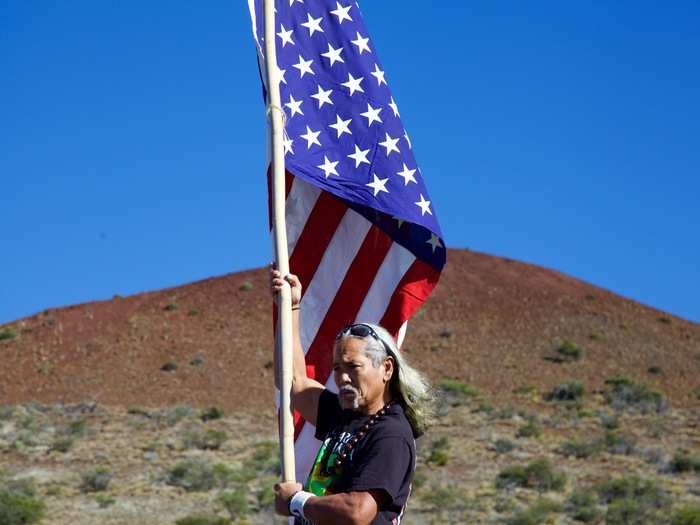 One man defiantly stood atop a ladder — right in the middle of the road. He waved an upside-down American flag in a complex act of defiance.