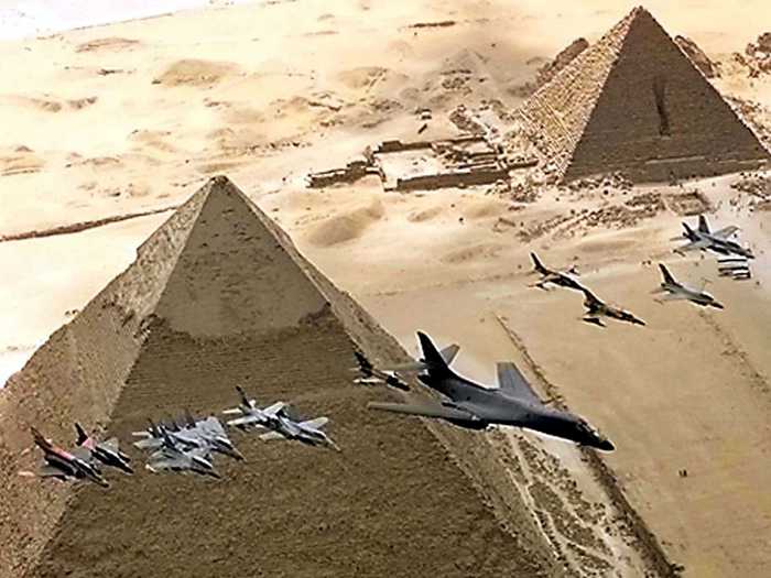 Fighter aircraft, led by a USAF B1-B tactical bomber, fly over the 4,500-year-old pyramids in Egypt.