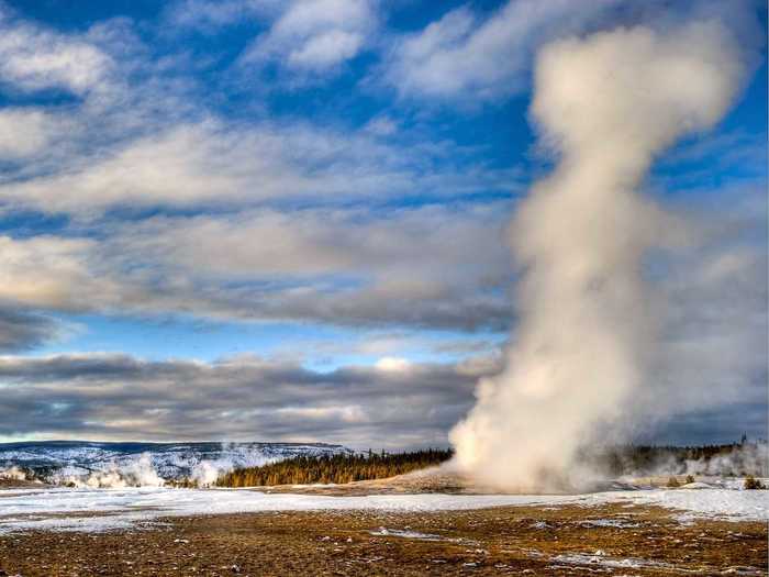 Wait for Old Faithful to erupt at Yellowstone National Park.