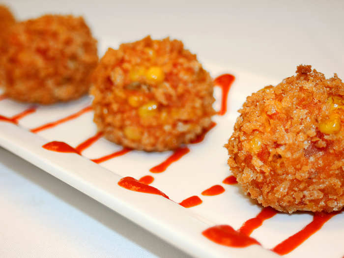 Sriracha Balls: Two choices of filling breaded in panko, deep-fried and drizzled with Sriracha sauce: blend of shredded chicken, corn, tomatoes, egg and Sriracha; or Sriracha cream cheese with corn, tomatoes and egg.