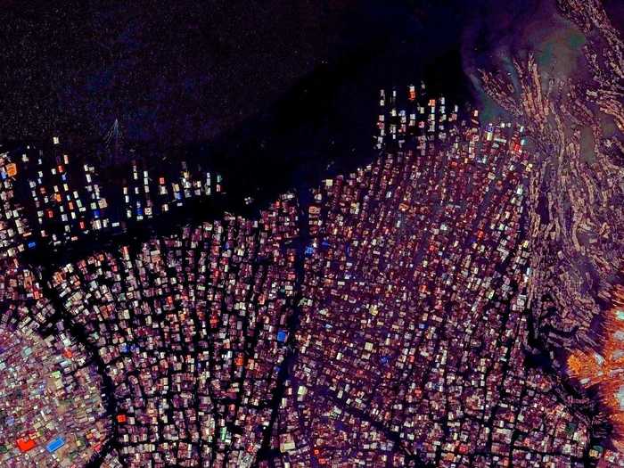 Makoko is a floating village in Lagos, Nigeria. Residents, approximately 85,000 in total, use wooden canoes to navigate the narrow canals and move about the neighborhood.