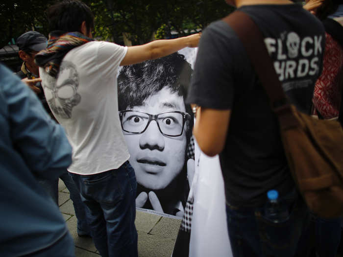 A man holds a portrait of himself taken as part of "Inside Out."