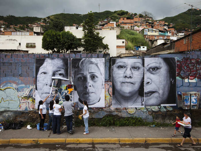 Volunteers in Caracas put up large portraits of women whose children were victims of violence in 2011. More than 50 portraits were pasted around the city as part JR