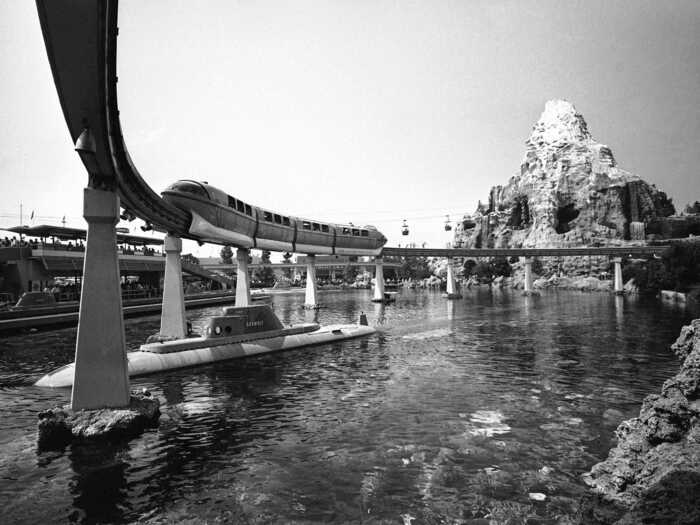 Trains carried guests from the Disneyland Hotel to the park on a monorail. In the background is the The Matterhorn Bobsleds, a roller coaster modeled after a mountain in the Swiss Alps.