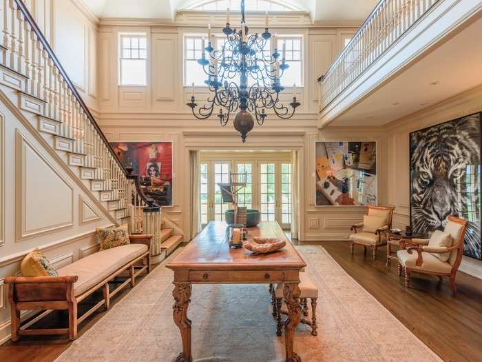 The portico leads into an open-ceiling traditional and rustic-styled foyer. Although don