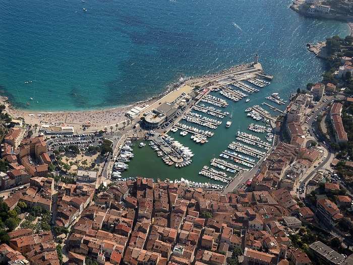 Beach goers swim in the Mediterranean Sea near the port of Cassis.