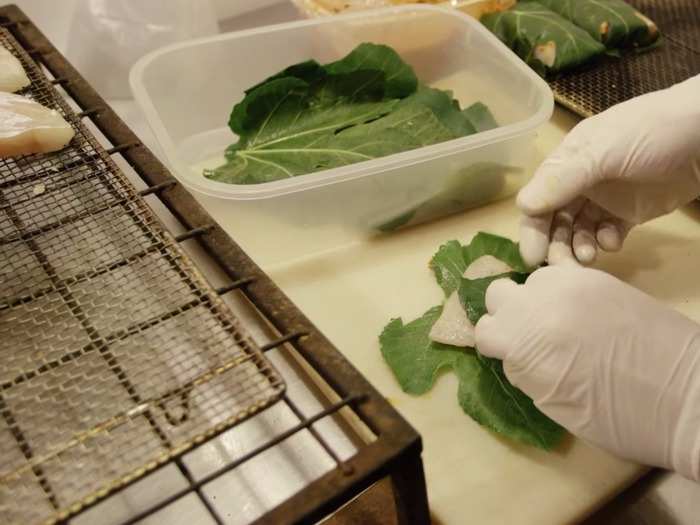 Here, chef Felix prepares fresh fish with vine leaves pulled from his backyard.