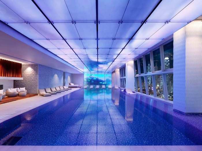 The Ritz-Carlton in Hong Kong offers a luxurious indoor infinity pool surrounded by sleek architecture and large windows that look out onto the city