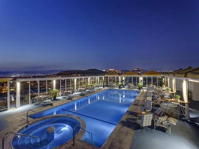 The pool at the Athens Ledra Hotel is surrounded by dining tables and towering glass windows that look out onto views of Athens. Go for a night swim and catch an unforgettable glimpse of the Acropolis when it