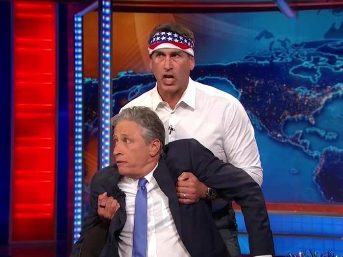 Rob Riggle showed up to protect Stewart from the upcoming video package of politicians, but first ...