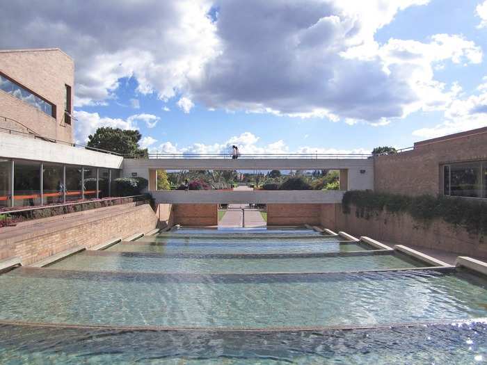 The Virgilio Barco Library in Bogotá, Colombia, was designed by well-known architect Rogelio Salmona and completed in 2001. The library has an open floor plan on the inside, and red brick, water pools, and lawns on the outside.