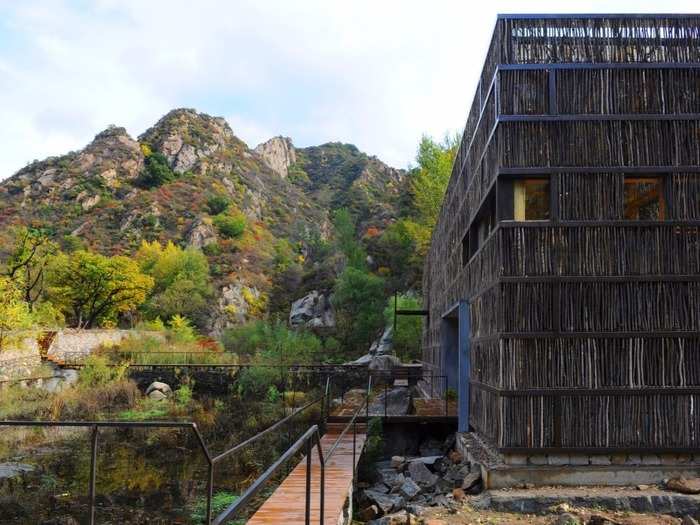 Taking a cue from its forest surroundings in a small town in Beijing, China, the exterior of the Liyuan Library is covered in sticks, and the interior is composed of timber beams. This eco-friendly library is cooled by the lake that it sits on.