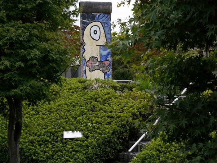 Here, a chunk of the Berlin Wall can be seen through lush trees in Yokohama, a Japanese city that sits south of Tokyo.