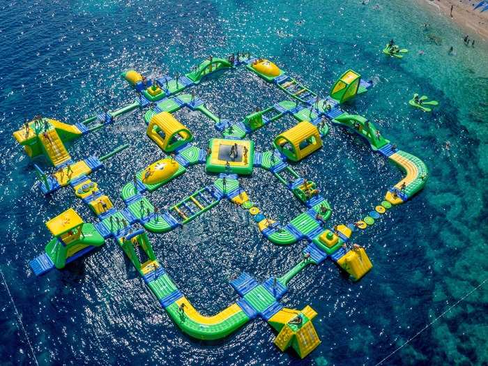 Wibit Sports GmbH is a German water sports company that produces innovative, water-based playgrounds created by architect Robert Cirjak. This one is located near Zlatni Rat in Bol, Croatia, and features swings, slides, and climbing structures. It