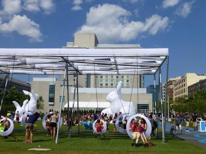 Swing Time is an interactive playground set up in a temporary park near the Boston Convention and Exhibition Center. Created by Höweler + Yoon Architecture, the play area features 20 illuminated swings that switch from white to purple when they