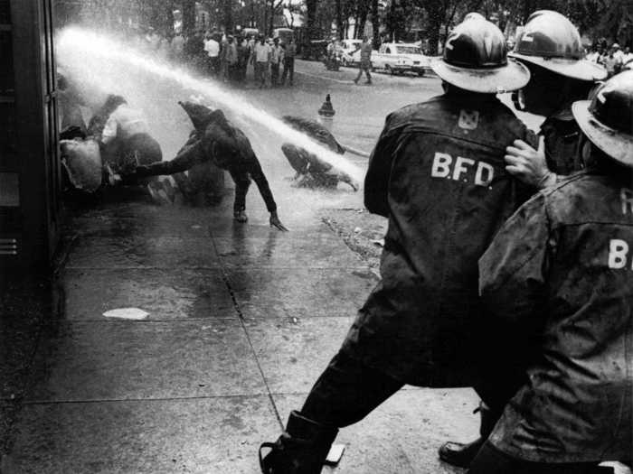 The situation in the South continued to worsen. Below, firefighters in Birmingham turn a high-powered hose on peaceful demonstrators. Bayard Rustin, the march