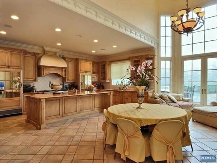 The kitchen opens to a double-height breakfast nook with a two-story window wall.