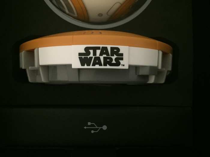 Beneath BB-8, you can see his charging station which is labeled with the "Star Wars" logo.