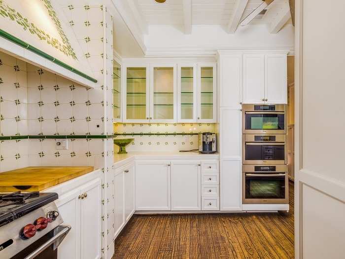 A spacious kitchen has interesting tile work and multiple ovens.