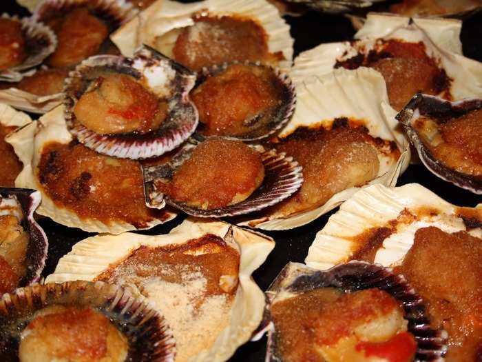 Zamburiñas are Galician scallops that are cooked in a tomato sauce and elaborated with olive oil. The scallops themselves are firm and take on the flavor of the tomato broth.