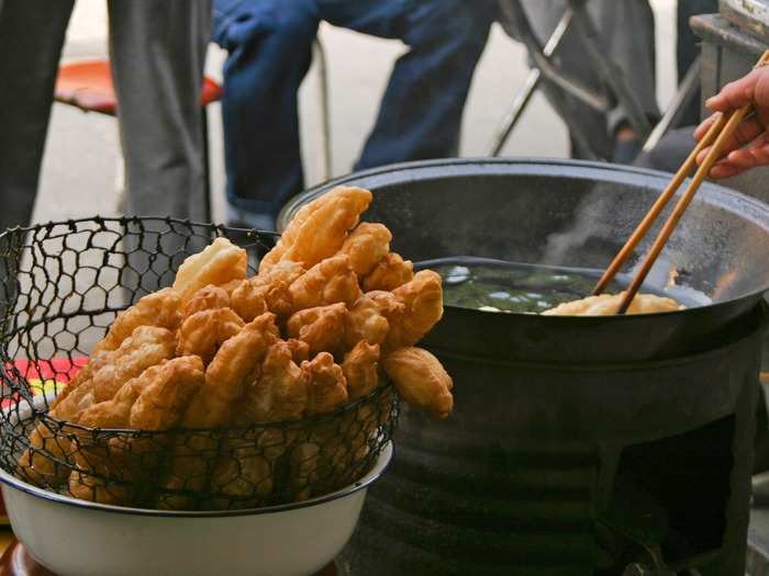 Known as the Chinese cruller or doughnut, you tiao are long strips of golden deep-fried dough. The snack is often eaten with congee and can be found on the street throughout most of the country.