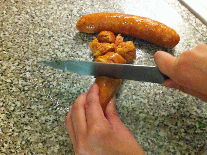 Now I have to "saute chorizo sausage...breaking up with back of spoon." I try to mash the whole sausages into bits but don