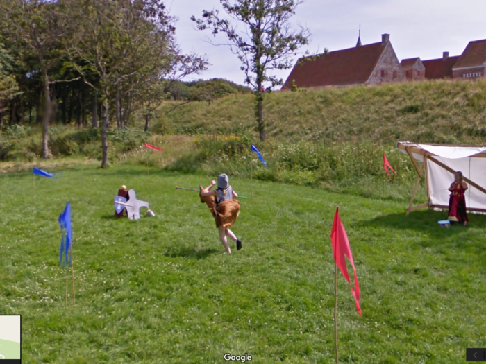 A young kid jousts while another watches from the stands in Denmark.