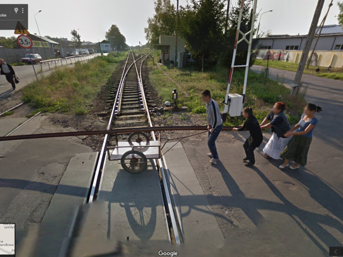 Here, a family of four helps each other wheel what appears to be a large stretch of train track in a tiny cart in Krosno, Poland. It looks like they