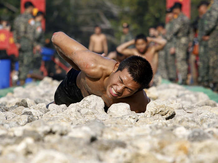 Taiwanese marines have to crawl through a rocky pathway in front of their fellow recruits to finish their training course.