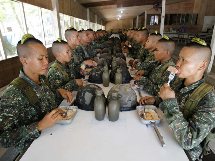 These Philippino recruits have to hold a banana on their heads while eating lunch to teach them balance and posture. If the banana falls, they have to eat it. Peel included.