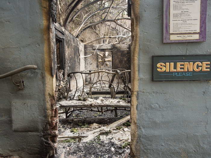 Deeper inside the resort, the inside of a bathhouse has been destroyed on the inside, but the "SILENCE" sign outside remains almost entirely untouched.