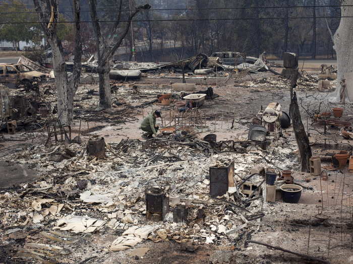 A woman returns to the remains of a home she once lived in as a child near Middletown, California.