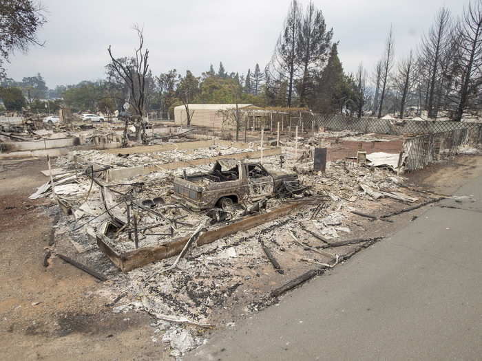 Homes and garages burned completely to the ground in Middleton, California, but some trees in the background still retain their green leaves.