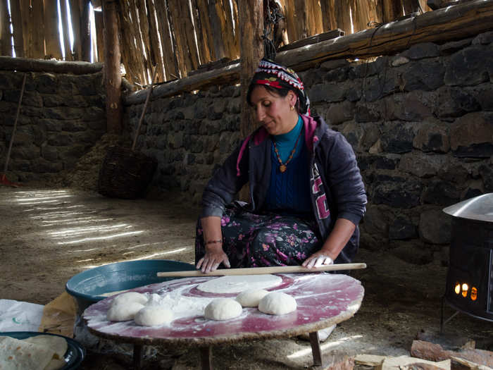 High in the Anatolian Plateau, this woman rolls out dough and prepares dinner while the men of the family look after the livestock.