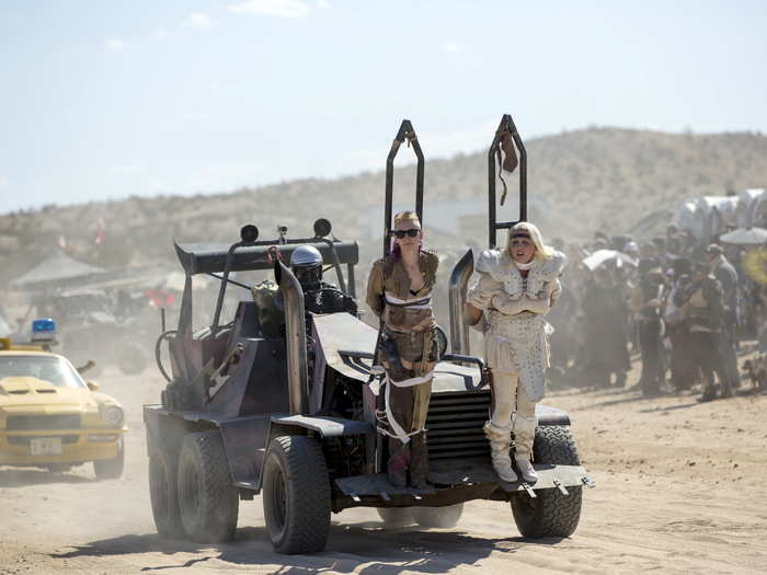 Post-apocalyptic societies are growing more and more popular in the entertainment world. Here, two "Mad Max" enthusiasts are tied to the front of a car and driven around the camp.