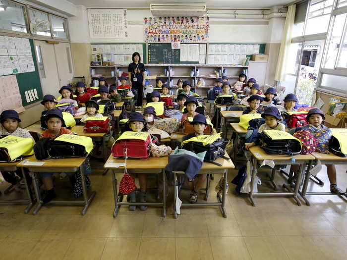 First-grade students and their teacher, Teruko Takakusaki, pose for a photo during their homeroom period at Takinogawa Elementary School in Tokyo, Japan.