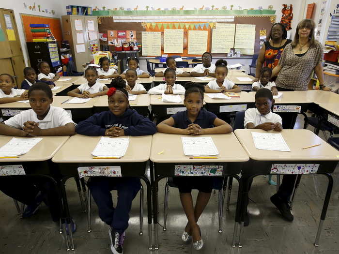 Teachers Carla Smith and Laura Johnson pose for a picture with their third-grade class at Jesse Sherwood Elementary School in the Englewood neighborhood of Chicago, Illinois.