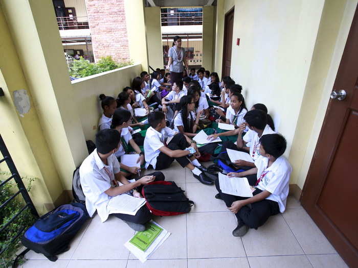 Students have class in the hallways of Timoteo Paez High School in Manila, Philippines. Their teacher says she is temporarily holding classes in the hallways while waiting for the completion of a new school building.