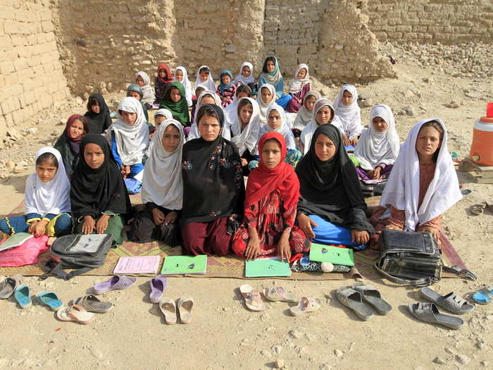 Teacher Mahajera Armani and her class of girls pose for a picture at their study open area outside of Jalalabad, Afghanistan. Beginning with the Soviet invasion in 1979, the country