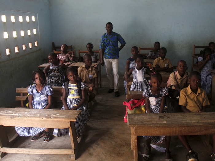 School teacher Kahon Rochel poses for a picture with students inside their classroom at the the EPV Sinai primary school in Abidjan, Ivory Coast. The country has a 56.9% literacy rate, but education is quickly becoming a priority.