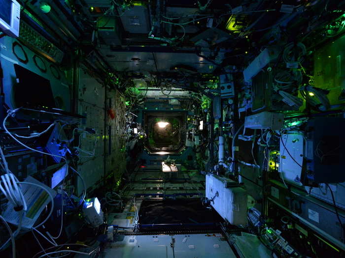 Dim blue lights create a captivating scene inside the orbiting ISS.