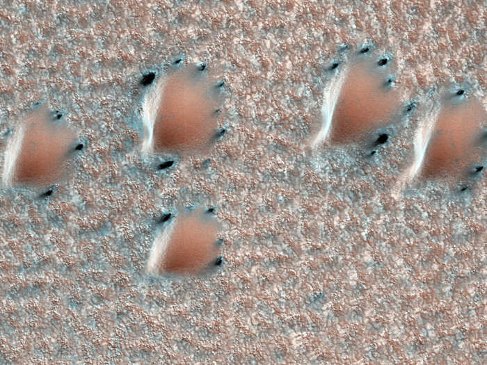 When the ice on Mars sublimates, wind can get at the exposed dirt and dust underneath. The black patches you see here in the planet