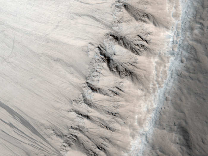 Geologists think that this textured terrain, which resembles features in the Colorado Plateau, formed when lava in the area cooled unusually quickly from flooding. For scale, the picture spans half a mile.