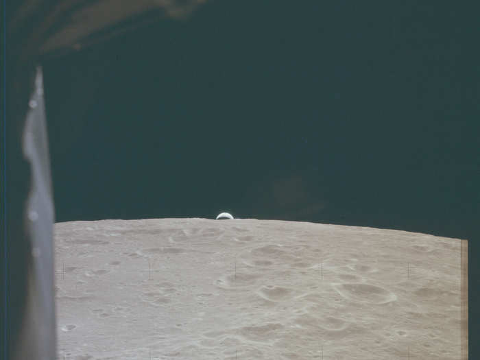 Apollo 12 — A sliver of Earth is visible over the edge of the moon.