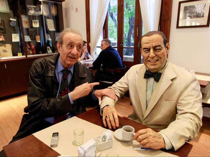 Lorenzo Pepe sits next to a statue of former Argentine President Juan Peron at the "Un cafe con Peron" restaurant in Buenos Aires. Although reviled by his critics as an authoritarian and forced to live in exile for almost two decades, Peron remained Argentina