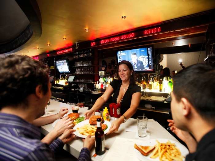 A ticker showing current drink prices runs behind the bar of The Exchange Bar & Grill in New York City. The Exchange is stock market–themed, with prices for food and beverages fluctuating like stock prices according to demand.